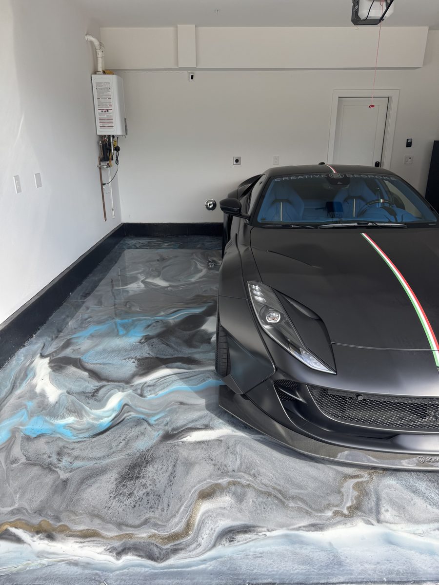 Matte black Ferrari on blue metallic epoxy floor